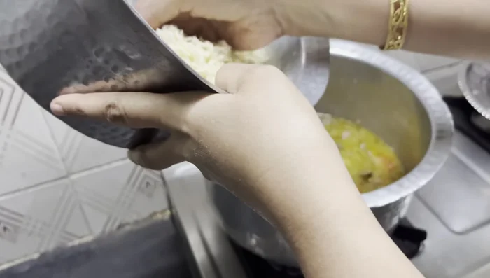 Add rice: Add the soaked and drained rice to the mixture. Stir in half a lemon's juice and mix well. (Add extra green chilies if desired).