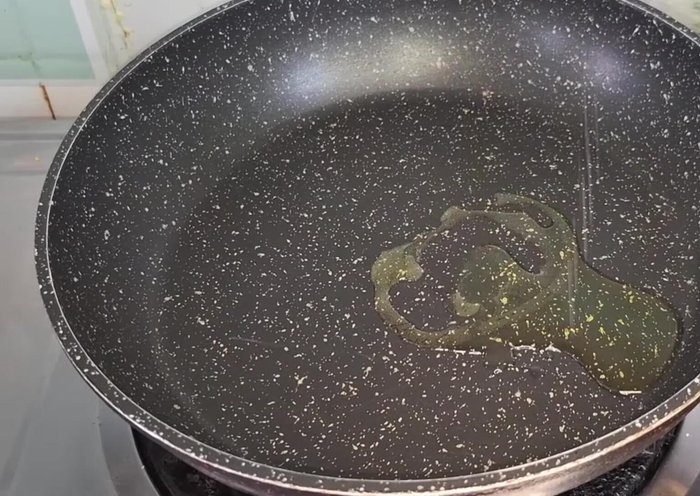 Heat 1 tbsp oil in a pan. Add 3 green cardamoms, 2 chopped onions, and fry until translucent.