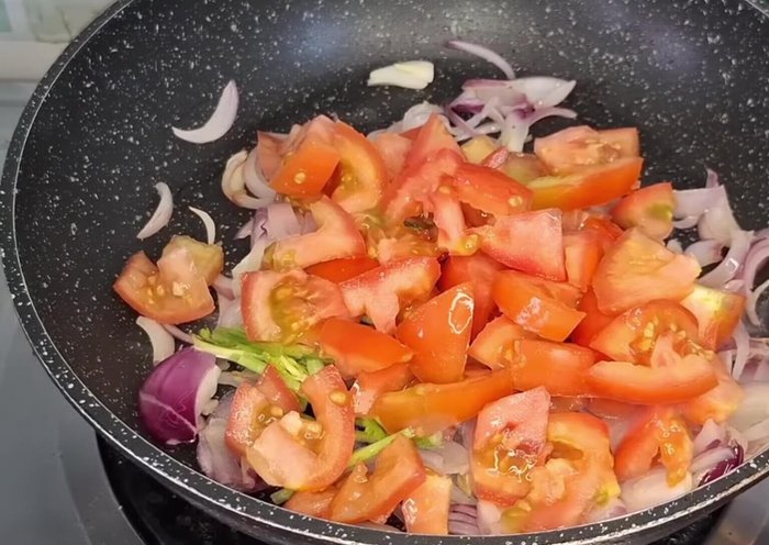 Add 4 chopped tomatoes, green coriander, ginger garlic paste (1 tbsp), Magaj (1/2 tbsp), cashews (1/2 tbsp), and salt. Cook until tomatoes soften.