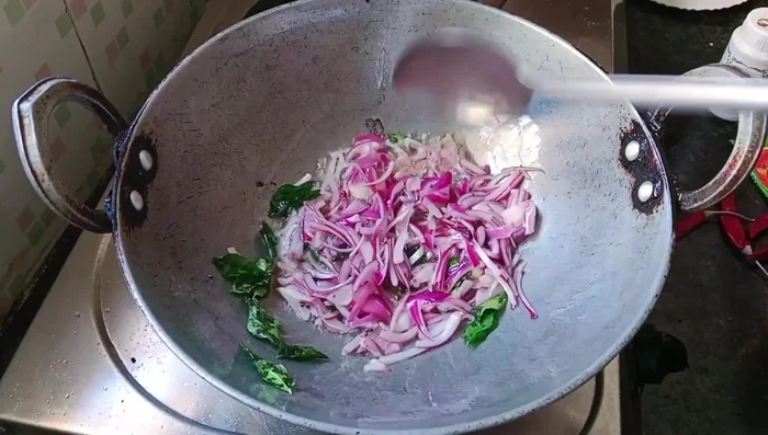 Add tomatoes and onions to the sambar. Season with mustard seeds, curry leaves, red chili (or green chili), and red chili powder. Add salt, sambar masala, and water. Simmer for a while.