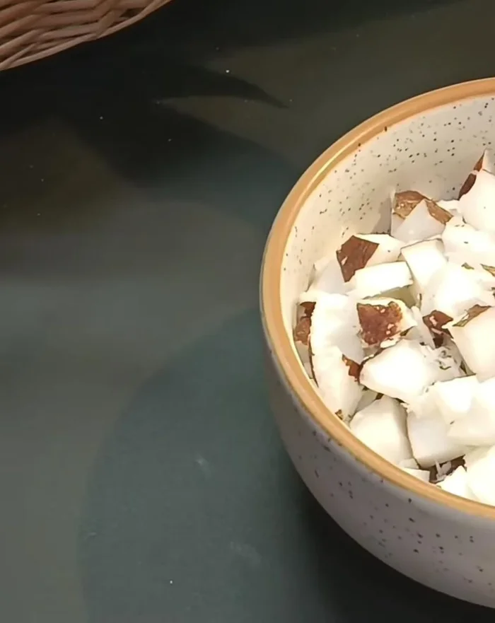 Prepare the coconut: Peel and cut the raw coconut into small pieces. Grind the pieces coarsely.