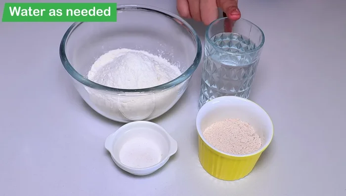 Prepare the dough: Mix refined flour, wheat flour, and salt. Gradually add water and knead into a smooth dough. Cover and let it rest for 10-15 minutes.