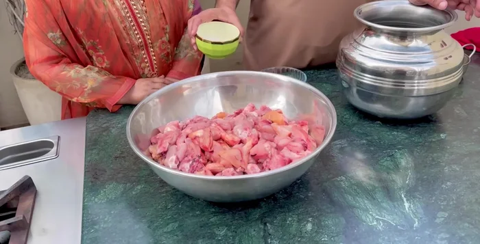 Wash the chicken thoroughly. Do not soak it. Apply Lahori salt and vinegar, add water, and beat well with your hands. Let it sit for half an hour.