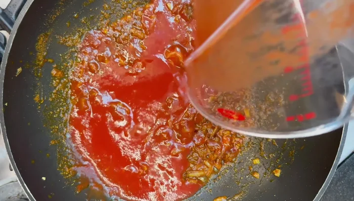 Add tomato puree mixed with water and curry based gravy. Stir.