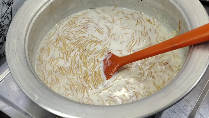 Once vermicelli is soft, add the custard mixture, sugar candy powder, and cardamom powder to the milk and vermicelli mixture.