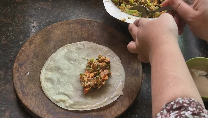 Spread the chicken mixture onto the roll sheet, roll tightly, and seal with the flour solution.
