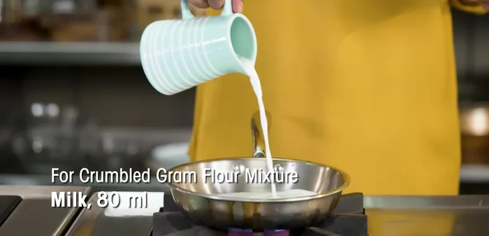 In a bowl, mix gram flour, milk, and 2 tbsp ghee. Rub the mixture between your palms until it becomes granular. (107.759)