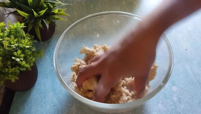 Gradually add the remaining sugar mixture, kneading to form a firm but not too hard dough, similar to roti dough.