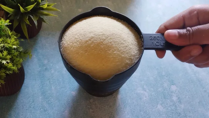 In a mixer jar, grind 1 cup semolina, ½ cup of the sugar mixture, and a little dry coconut (or desiccated coconut powder).