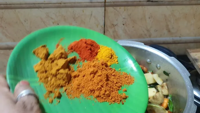 Add turmeric powder, coriander powder, sambar powder, and salt. Mix well.