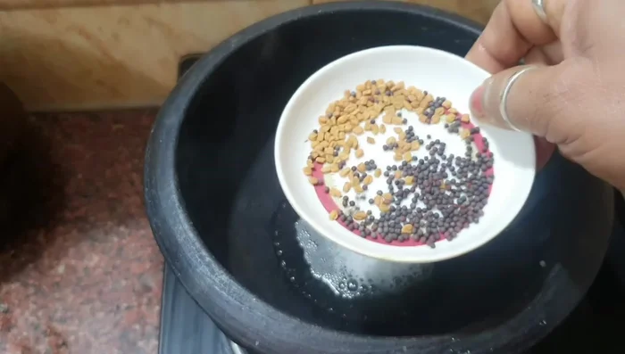 Heat coconut oil in a clay pot. Add fenugreek and mustard seeds; fry until fragrant.