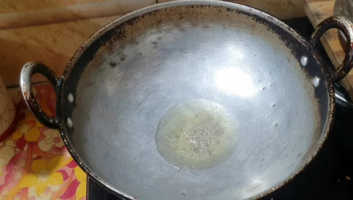 In a pan, heat oil and add mustard seeds, turmeric powder, and red chilies. Fry until the mustard seeds crackle.