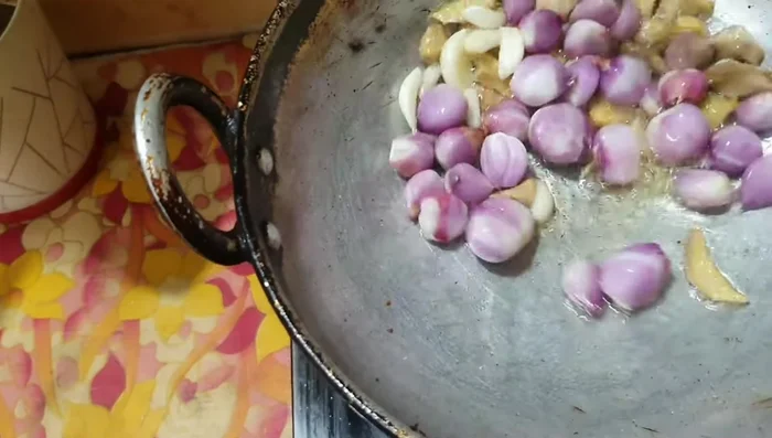 In a glass dish, fry 6 garlic cloves and 20 small onions.