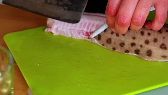 Skin the shark using pliers to remove the skin from one side and rolling it around the pliers.