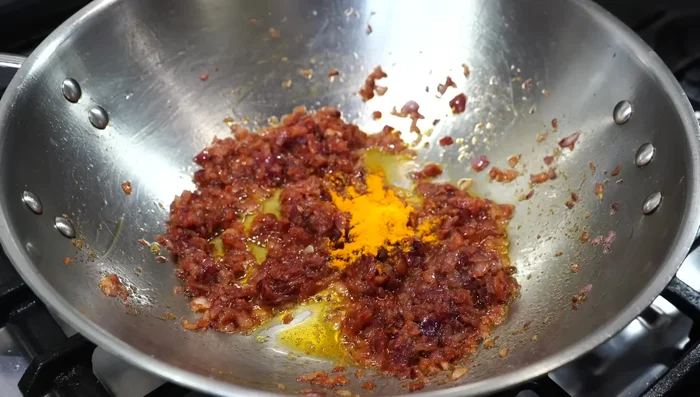Add turmeric powder, Kashmiri chili powder, ground coriander, and cumin powder. Fry for a few seconds on low heat.