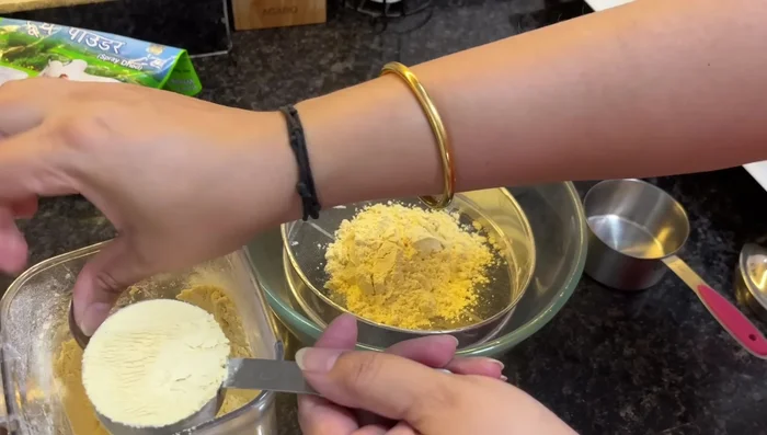 Sift gram flour to remove lumps. Mix with milk powder.
