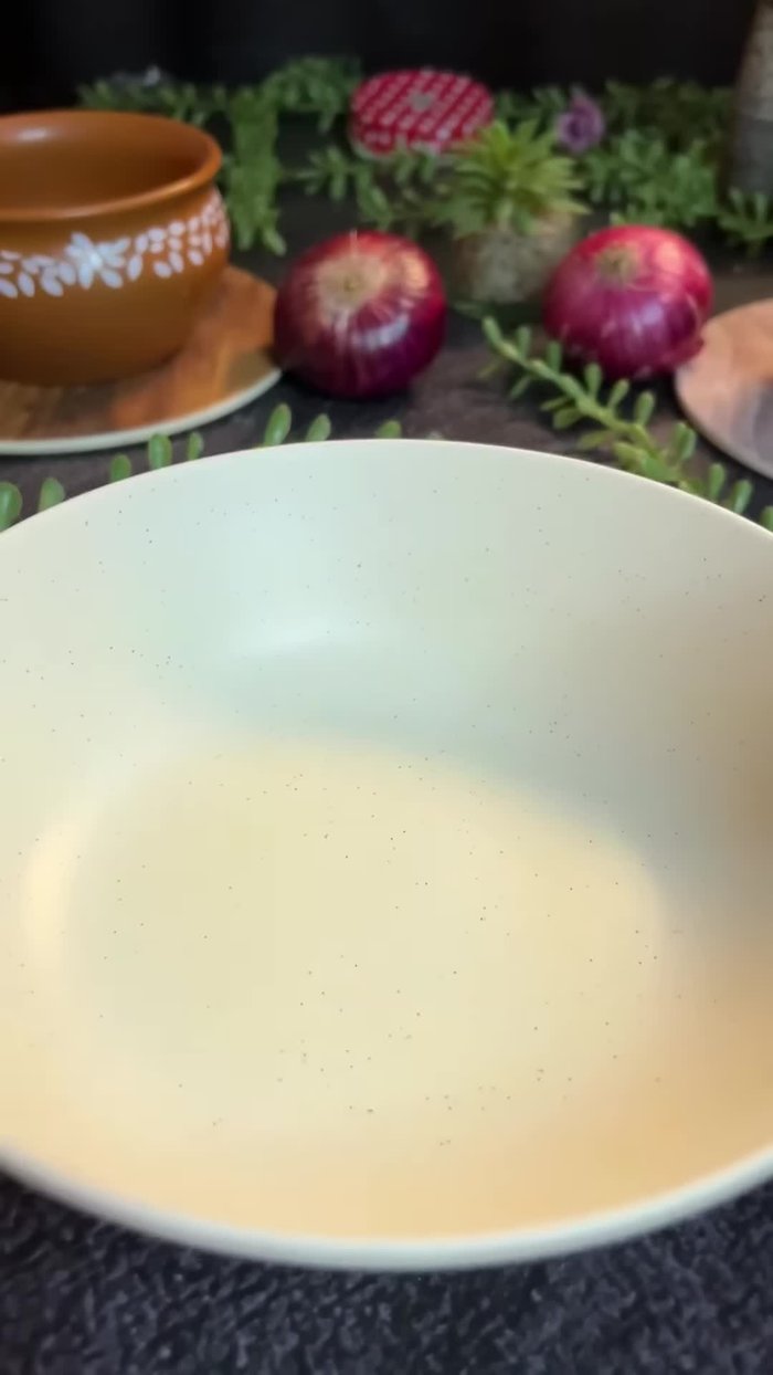 In a vessel, mix curd, cumin powder, red chili powder, and turmeric powder.