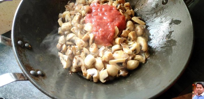 Once mushrooms release water, add a pureed medium-sized tomato and the prepared spicy mustard masala.