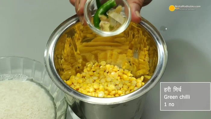 Grind the soaked gram dal with 1 green chili, 1/2 inch ginger, 1/2 teaspoon fenugreek seeds, and 2 tablespoons of water until smooth.