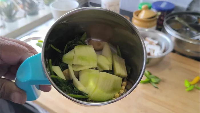 Add the sliced mango, more curry leaves, and coconut to the blender.
