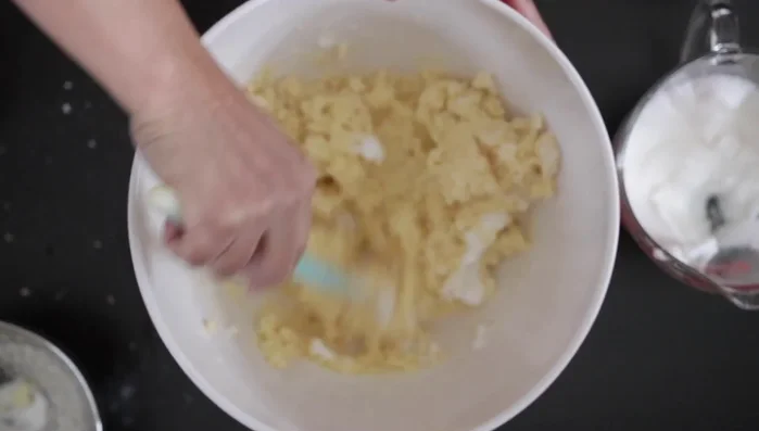 Fold in almost half of the whipped egg whites, a tablespoon at a time.