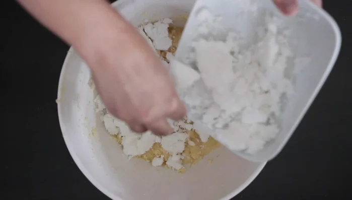 Add 3 cups grated coconut (adjust if using fresh coconut), rose water, and baking powder. Mix well.