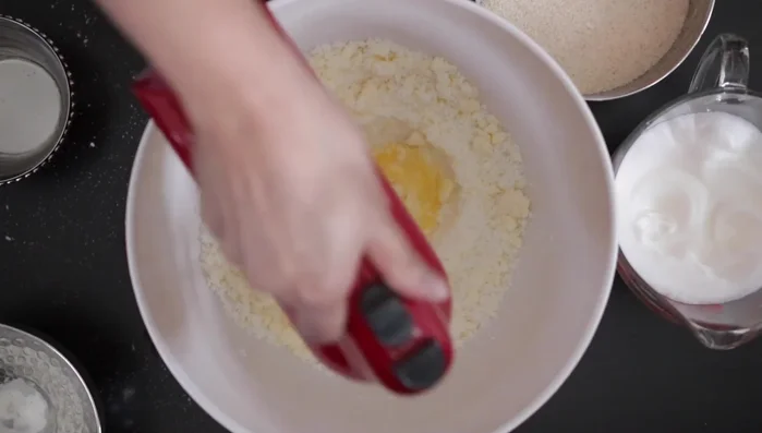 Add 2 egg yolks one at a time, beating to incorporate.