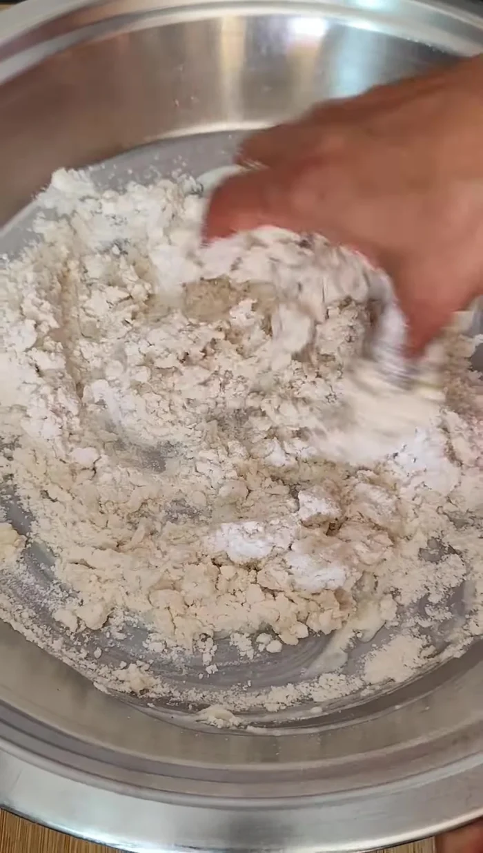 Add the sieved flour and mix well. Add 1-2 tablespoons of water, keeping the dough slightly hard. Add ghee and mix thoroughly to prevent sticking.
