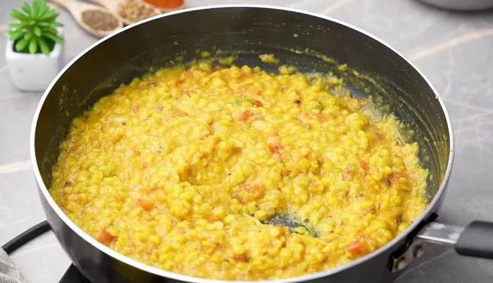Add the boiled dal to the pan and mix. Add water to adjust consistency.