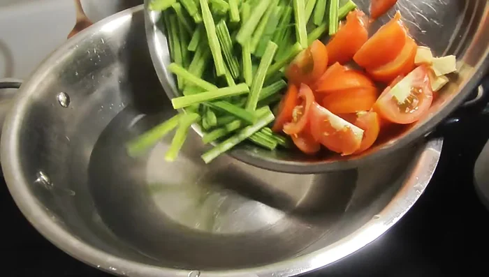 Heat water in a pot. Add chopped tomatoes, horse gram, and ginger. Boil for 5 minutes.
