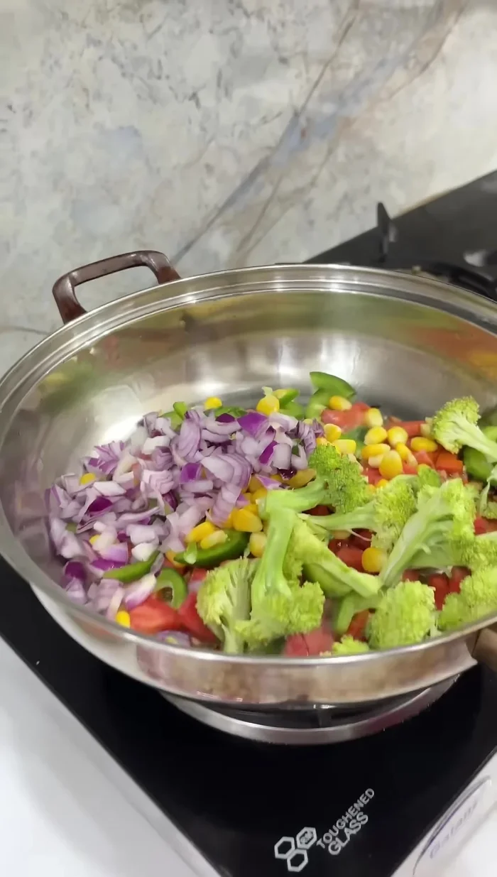 Add water to the sautéed vegetables and simmer until cooked.