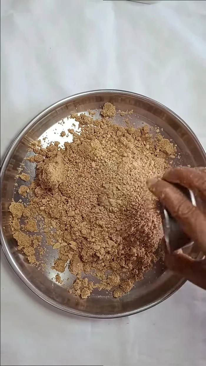 Add the crushed Sangdana and the reserved sesame seeds to the ground sesame seed mixture. Mix well.