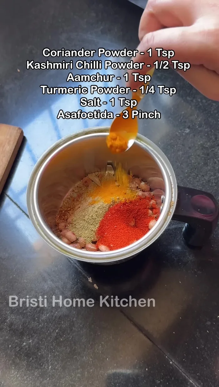 Grind the fried mixture with coriander powder, Kashmiri red chilli powder, dried mango powder, turmeric powder, salt, asafoetida, and optional garlic (186.879).