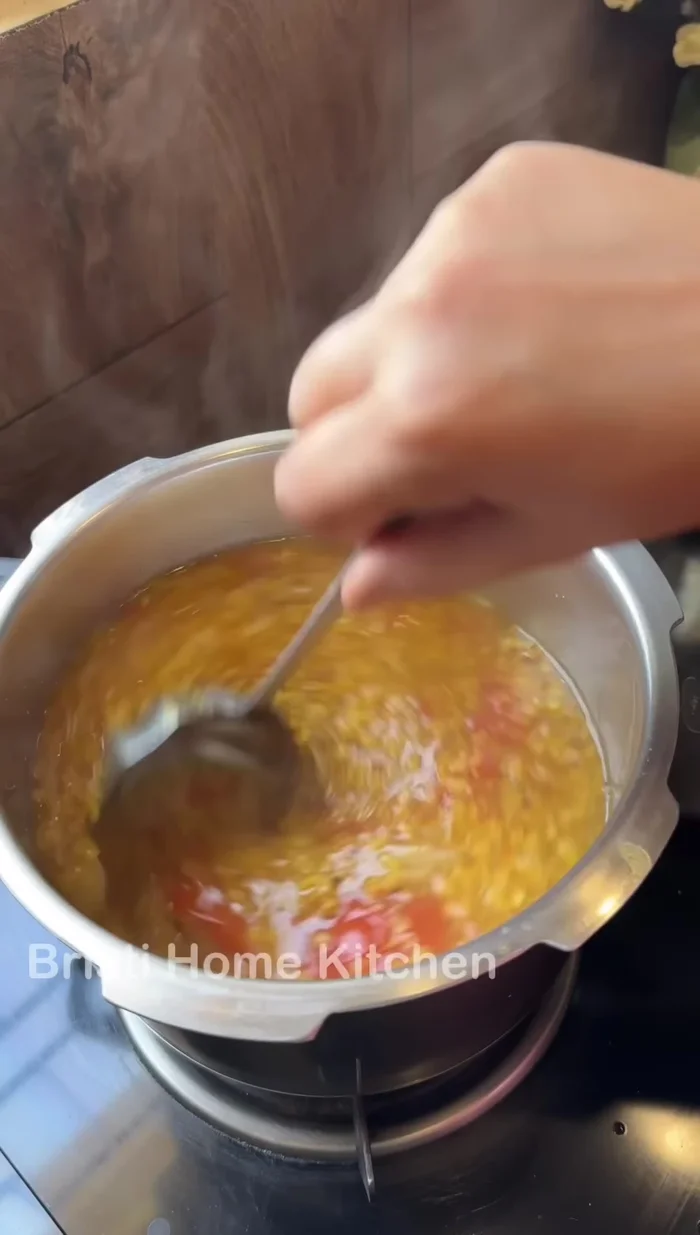 Remove tomato peels from the cooked dal and stir with a whisk (259.88).