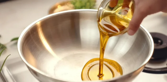 Heat mustard oil in a pan. Add cumin seeds, asafoetida, and chopped garlic. Saute for a while.
