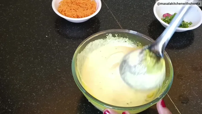 Add the tempering to the batter and mix well. Add chopped coriander leaves and carrots (or other vegetables like onions and capsicum). Mix thoroughly.