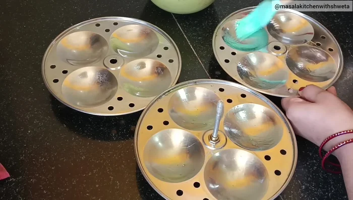 Grease an idli steamer with oil. Pour the batter into the idli molds.