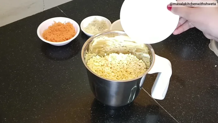 Grind the moong dal in a mixer jar without adding water initially. Add 1/4 cup curd.