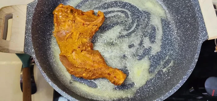 Place marinated chicken pieces in the pan, adding a little water to help with the cooking process.