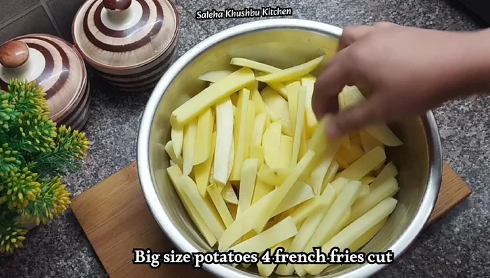 Cut the potatoes into French fry shapes and soak them in water to prevent browning.