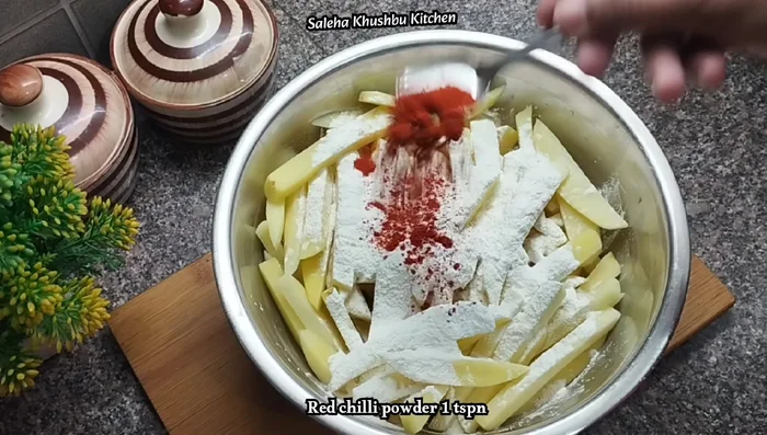Drain the potatoes and add corn flour, all-purpose flour, red chilli powder, salt, and pepper. Mix well until dry coated.