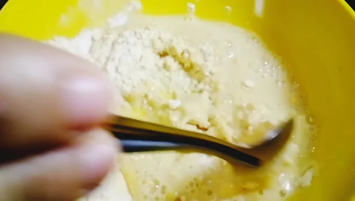 Gradually add water to create a thin, lump-free batter.