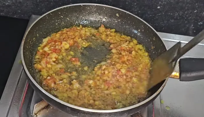 Add chopped onion and tomato (if using), then add the prepared mustard paste after 1-2 minutes.