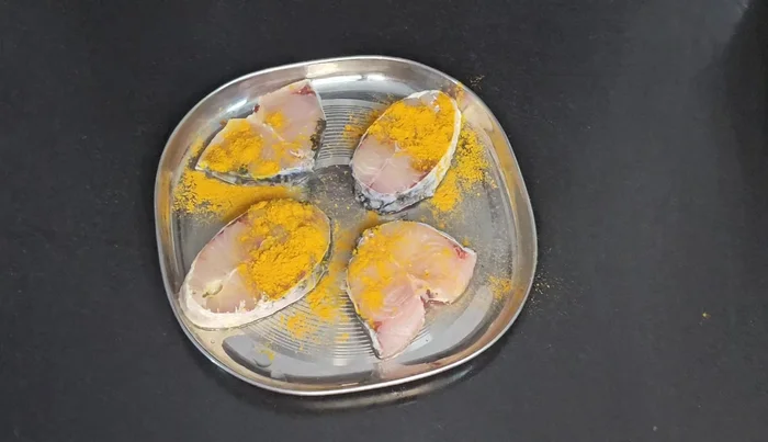 Clean the fish thoroughly. Add turmeric powder and salt, mixing well on both sides.
