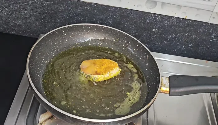 Heat mustard oil in a pan. Fry the fish until well-browned on both sides.