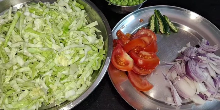 Finely chop the cabbage and wash it thoroughly. Chop one tomato, one onion, and three green chilies.