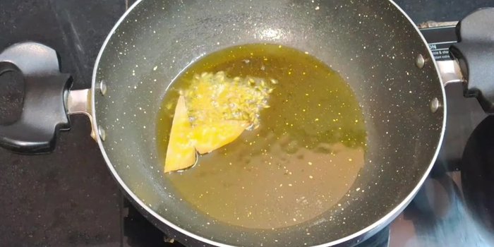 Add less than half a teaspoon of cumin seeds and one bay leaf. Let the cumin seeds crackle.