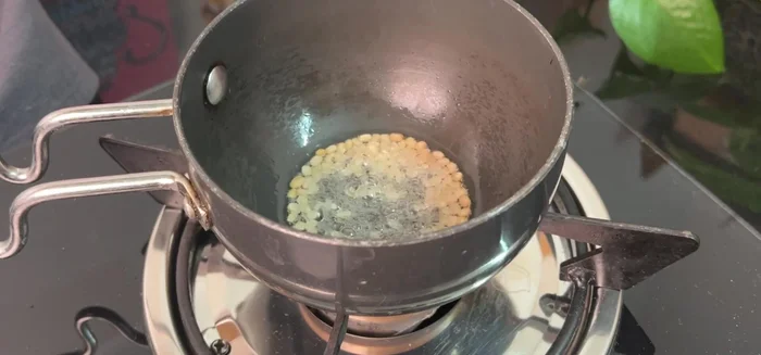 Make a tadka for the chutney: Heat oil, urad dal, mustard seeds, asafoetida, chilies, and curry leaves. Add to the chutney and mix.