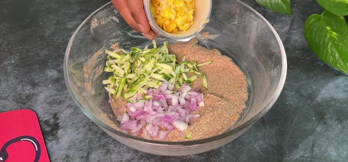 Add grated zucchini, chopped onion, sweet corn, and green coriander to the idli batter. Adjust salt.
