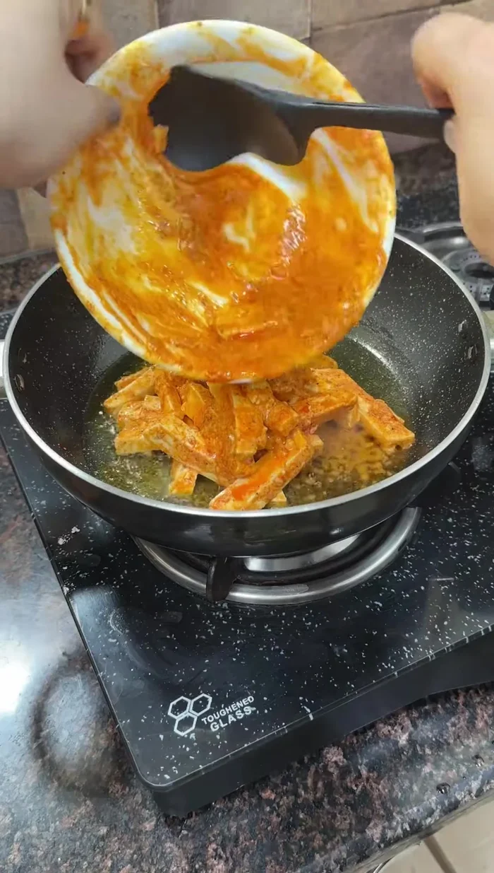 Cook the marinated paneer in a pan with oil until the masala coats it well and moisture reduces slightly.